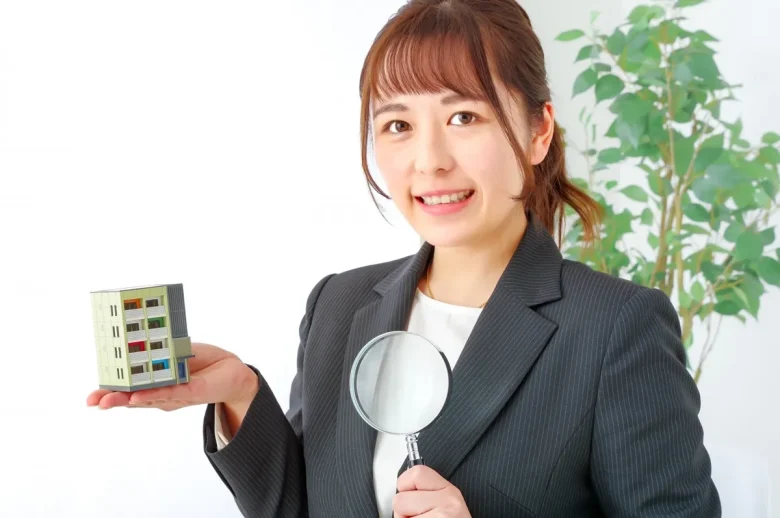 ビル模型とルーペを持つ女性