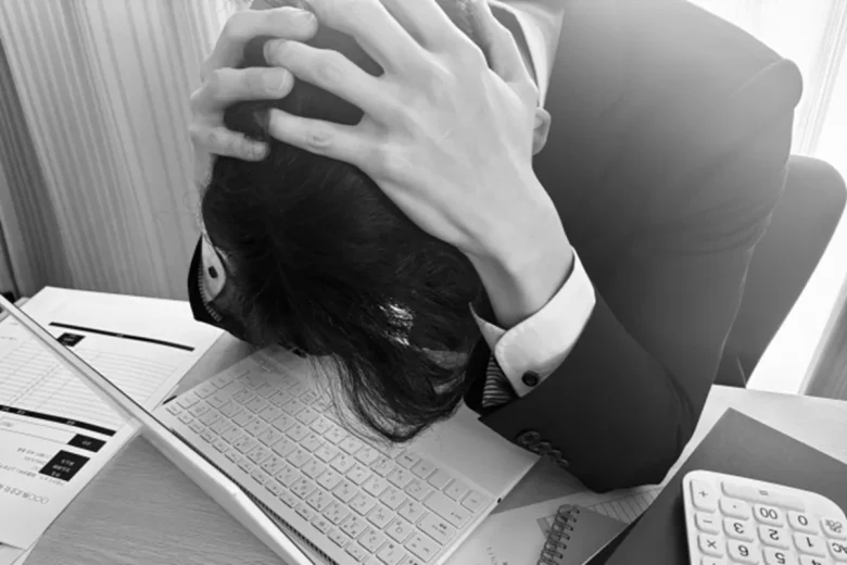 頭を抱えるビジネスマン(モノクロ)