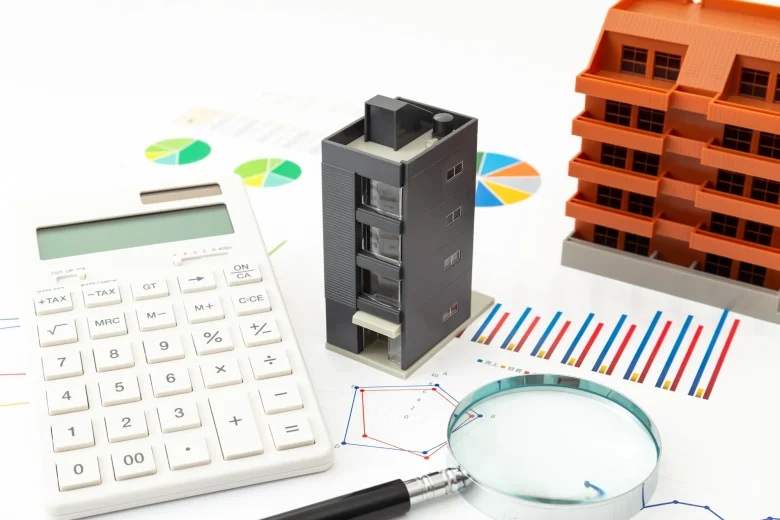 電卓とマンションの模型と虫眼鏡