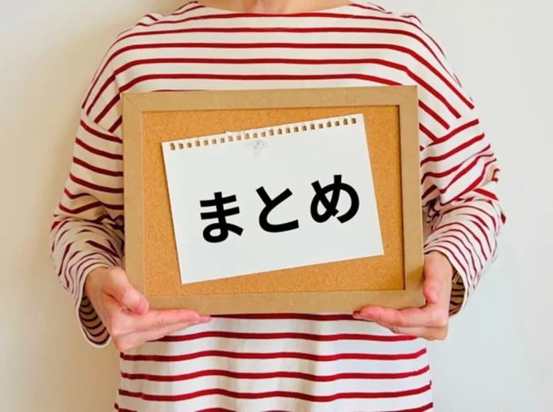 「まとめ」と書かれた紙を持つ女性