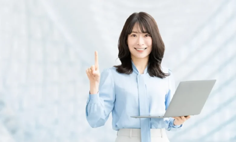 パソコンを持って案内をする笑顔の女性