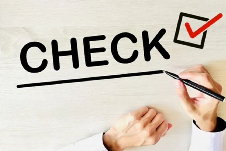 机にチェックの文字を書く手